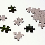 Scattered puzzle pieces next to solved fragment